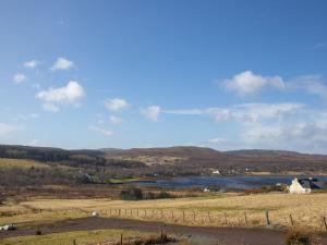 a view of a lake in a field with a fence at Chalet Skeabost Chalet by Interhome in Tole