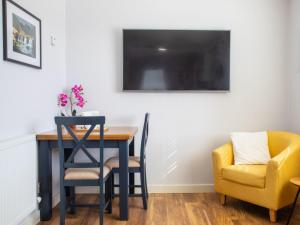 a dining room table and two chairs and a tv at Chalet Skeabost Chalet by Interhome in Tole