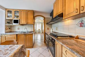 a kitchen with wooden cabinets and a stove top oven at Appartamento Pisani in Brez +12 photos