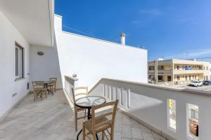 a balcony with chairs and a table on a building at Affittacamere Arcobaleno in Torre San Giovanni Ugento