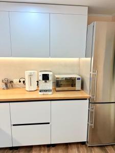 a kitchen with white cabinets and appliances on a counter at Hostel Chisinau Centru in Chişinău