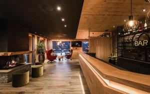 a restaurant with a bar with a counter and chairs at Bruneggerhof Weissenbach in Rio Bianco