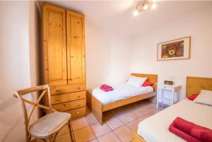 a bedroom with two beds and a cabinet and a chair at Ca Na Magda in Port de Soller