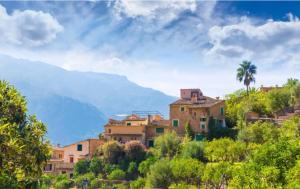 a village on a hill with mountains in the background at Ca Na Magda in Port de Soller