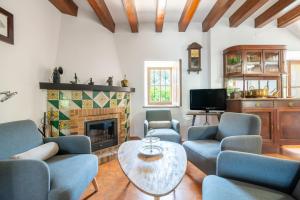 a living room with blue chairs and a fireplace at Ca'n Repic in Port de Soller