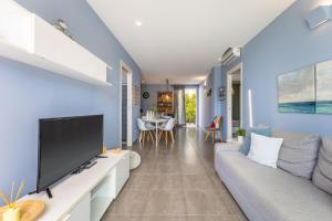 a living room with a tv and a couch at Villa Heraia con piscina in Marina di Ragusa