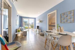 a dining room and living room with a table and chairs at Villa Heraia con piscina in Marina di Ragusa