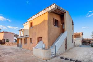 a building with a staircase on the side of it at La finestra sul mare in Budoni