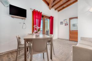 a dining room with a table and chairs and a tv at La finestra sul mare in Budoni
