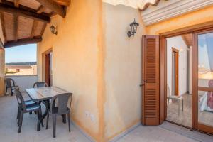 a dining room with a table and chairs on a patio at La finestra sul mare in Budoni