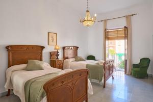 a bedroom with two beds and a chandelier at Vtar Casa Palacio Vida in Espejo