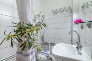 a bathroom with a sink and a toilet and flowers at Nikiana Club - Studio 2 in Nikiana