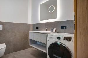 a bathroom with a washing machine and a sink at Haus Weinblick Apt 3 in Magrè allʼ Adige +26 photos