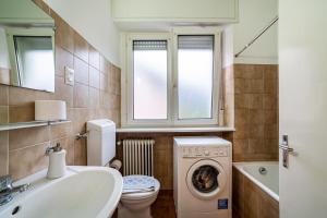 a bathroom with a sink and a washing machine at Residence Hubertus Apartment 4 in Merano +8 photos