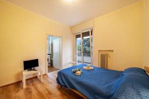a bedroom with a blue bed and a television at Residence Hubertus Apartment 4 in Merano