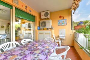 a dining room with a table and chairs on a balcony at Appartamento Trilo Fucini in Campo nell'Elba