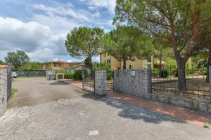 a fence in front of a house with trees at Appartamento Trilo Fucini in Campo nell'Elba
