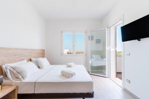 a white bedroom with a bed and a balcony at Le scuderie 9 in Galatone
