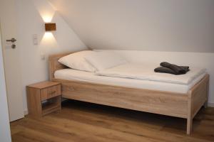 a bedroom with a bed with white sheets and a night stand at Ferienhaus Hanni in Geeste