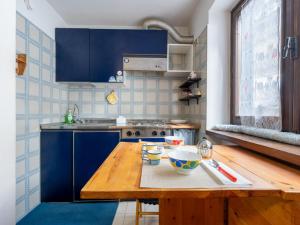 a kitchen with blue cabinets and a wooden table at Apartment Richardette by Interhome in Sauze d'Oulx