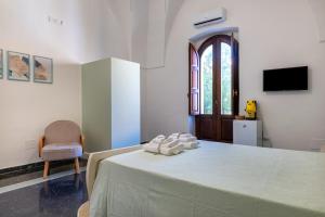a bedroom with a bed and a chair and a television at Gma Home Primo Piano in Pulsano