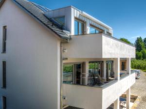 an external view of a white house with large windows at Alpenblick 3 in Lindau-Bodolz