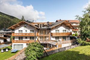 an apartment building in the mountains with a yard at Apartment Cater Residence Bun Ste in San Vigilio Di Marebbe