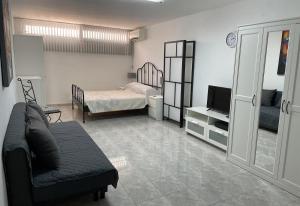 a living room with a couch and a bed and a television at Salida Del Sol in Nerja