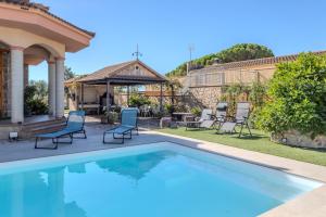 a swimming pool with chairs and a gazebo at Villa natura 20 km de las playas in Sils
