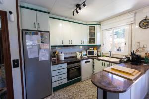 a kitchen with green and white cabinets and a counter at Villa natura 20 km de las playas in Sils