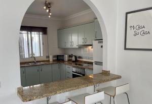 a kitchen with white cabinets and a granite counter top at Salida Del Sol in Nerja