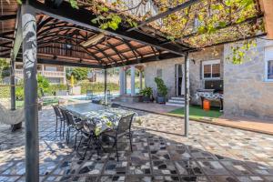 a patio with a table and chairs under a pergola at Villa natura 20 km de las playas in Sils