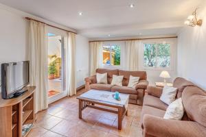 a living room with a couch and a tv at Can Parets in Santanyi