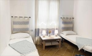 a room with two beds and a table with two lamps at Apartment Ida Isuledda 1 in San Teodoro +9 photos