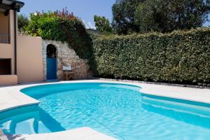 a swimming pool in front of a hedge at Apartment Ida Isuledda 1 in San Teodoro