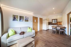 a living room with a couch and a kitchen at Flatschhof - Apartment Cevedale in Kastelbell-Tschars