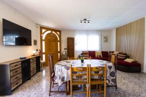 a dining room with a table and a living room at Villa natura 20 km de las playas in Sils
