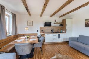 a kitchen and living room with a wooden table and chairs at Fewo beim Nik mit Wanderreitstation in Höslwang