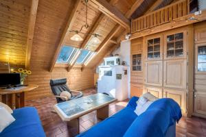 a living room with a blue couch and a kitchen at Das kleine Paradies in Pürgen +28 photos