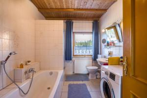 a bathroom with a tub and a toilet and a sink at Das kleine Paradies in Pürgen