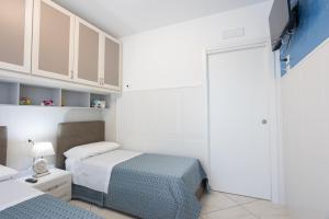 a small bedroom with two beds and a closet at La Casa Vacanza Dei Sogni in Paestum