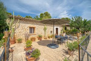 a patio with a table and an umbrella at Can Pulit in El Port de la Selva