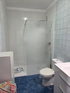 a white bathroom with a toilet and a shower at Casa Laly in Callao Salvaje +18 photos