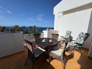 a patio with a table and chairs on a balcony at Casa Laly in Callao Salvaje