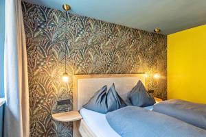 a bedroom with a bed with blue pillows against a wall at Luisalle Top 5 in Auffach