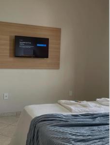 a bedroom with a tv on the wall at Hotel Dias in Mucurici