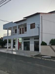 a white building on the side of a street at Hotel Dias in Mucurici