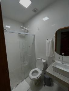 a bathroom with a shower and a toilet and a sink at Hotel Dias in Mucurici