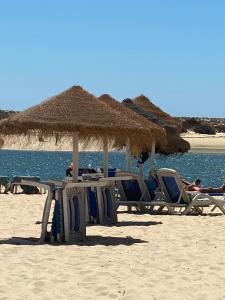 a group of chairs and umbrellas on a beach at Casa Anzol in Fuzeta
