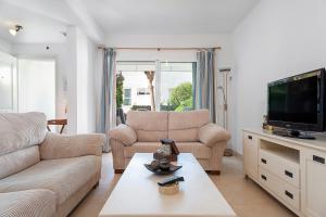 a living room with two couches and a tv at Casa Alena in Conil de la Frontera